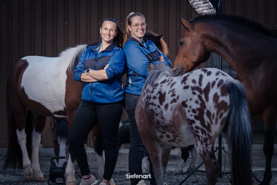 Zwei Frauen inmitten ihrer Pferde und Ponys