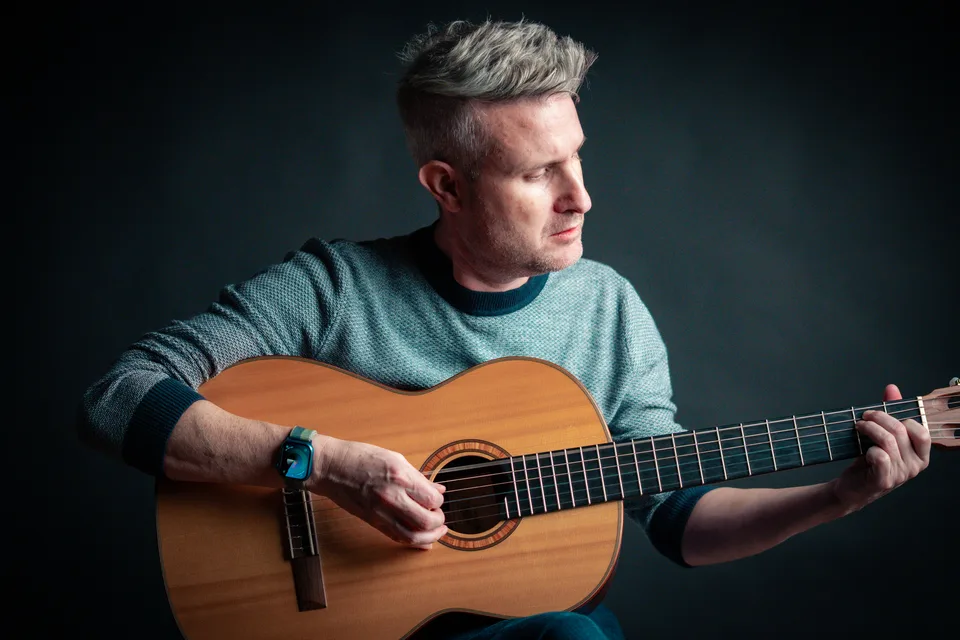 Portrait eines Musikers mit seiner Gitarre